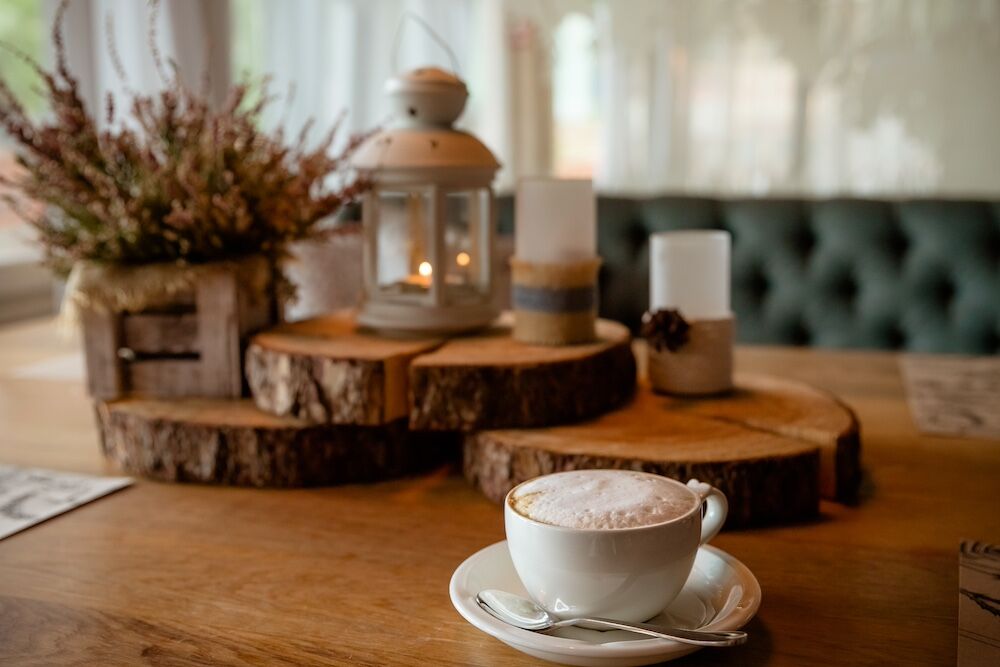 A cup of coffee and winter decor on a coffee table