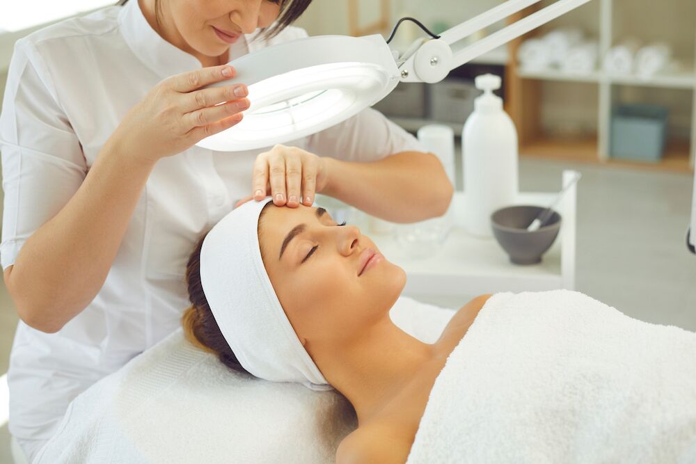 A young woman getting a facial at the spa
