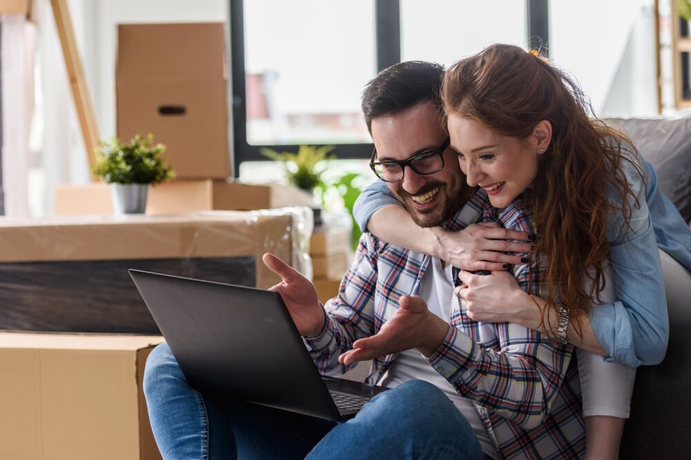 A couple look at their laptop searching for luxury apartments kc
