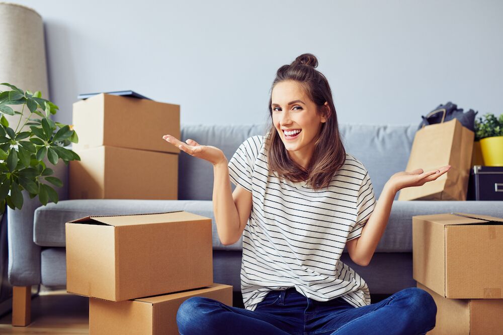 A woman sitting with her stack of packed boxes