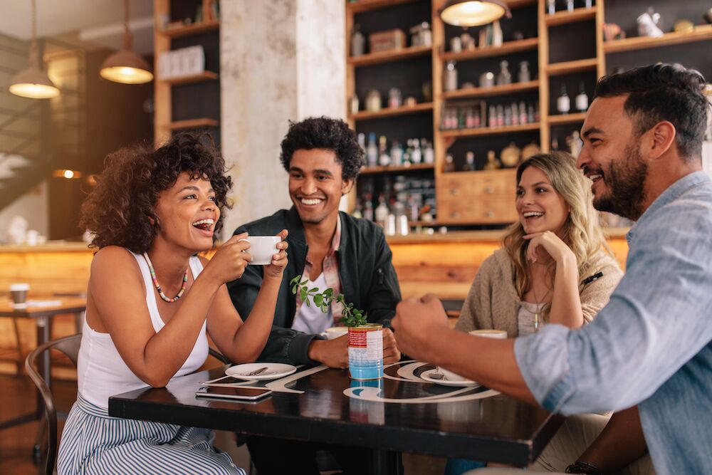 Four friends drinking coffee in a cafe