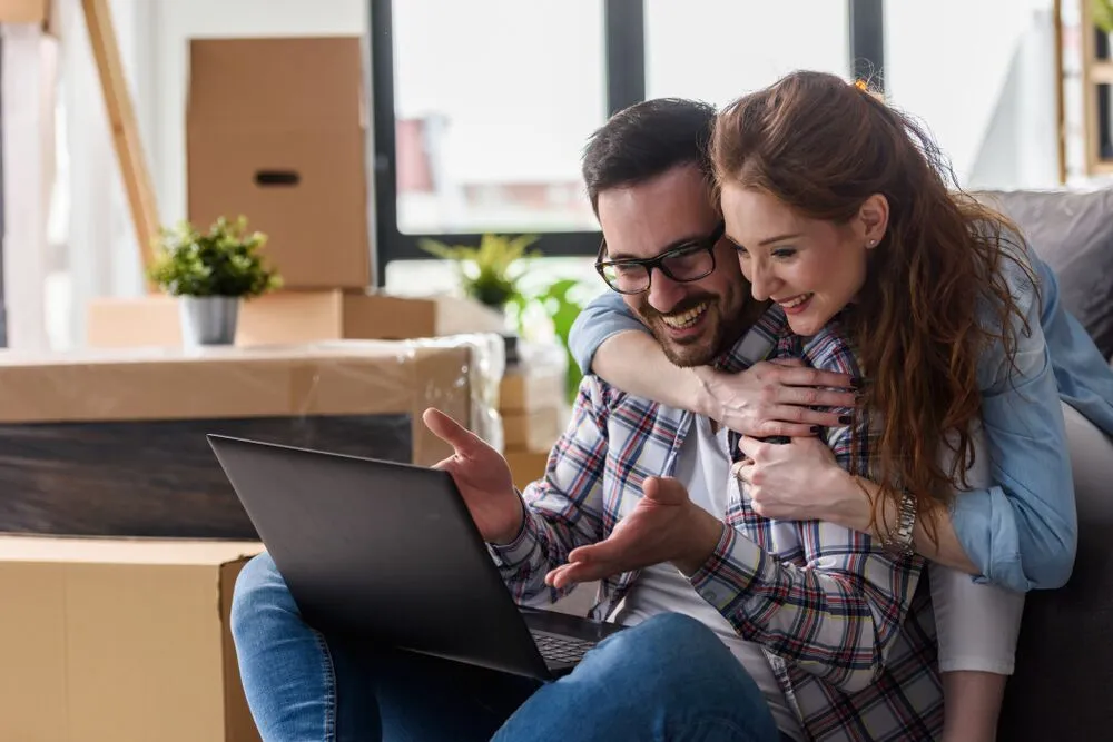 A couple look at their laptop searching for luxury apartments kc