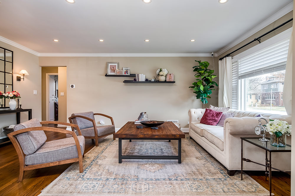 Spacious living room with two chairs, sofa, coffee table, and large area rug