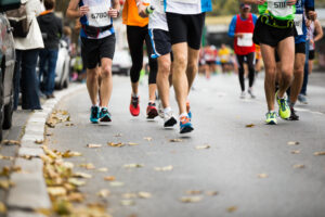 Marathon runners job down an autumn road