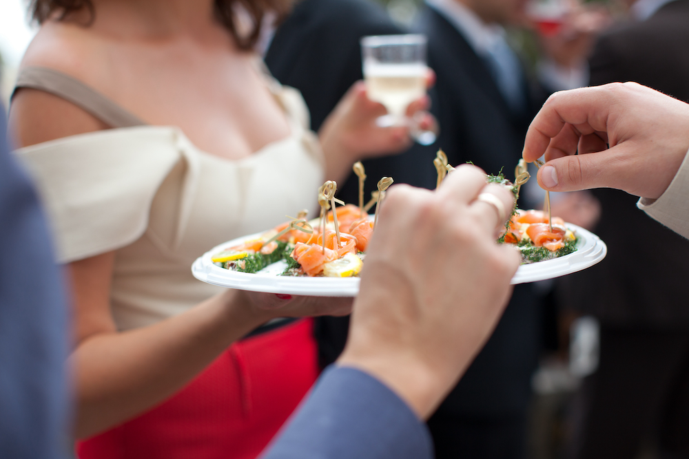 Partygoers reaching for finger foods