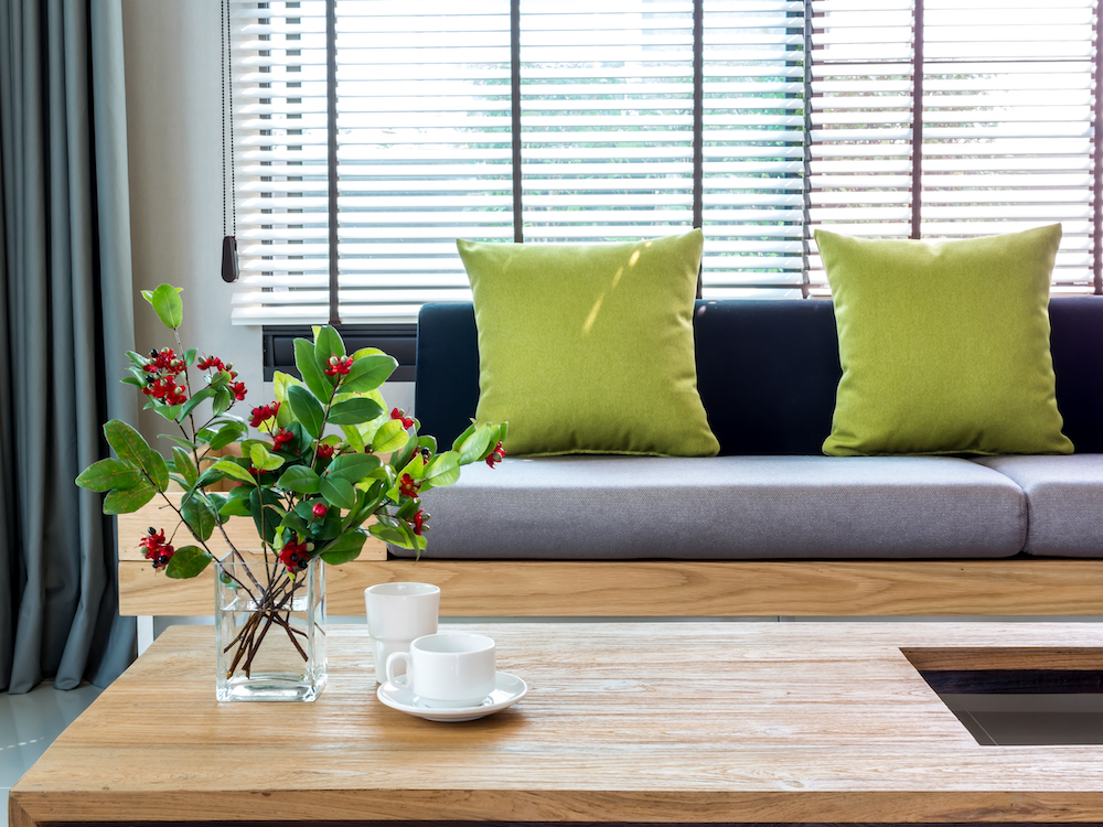 A bright living room with throw pillows and flowers