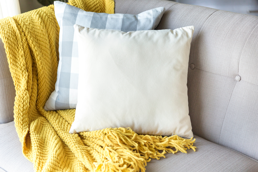 A throw blanket and pillows on a sofa
