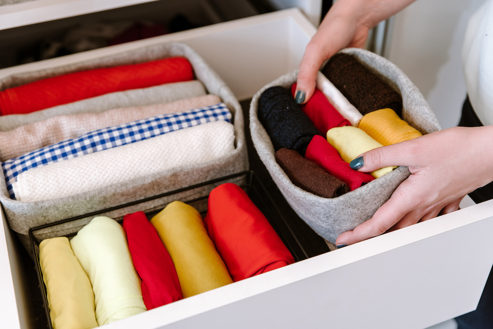 A woman organizes her closet drawers