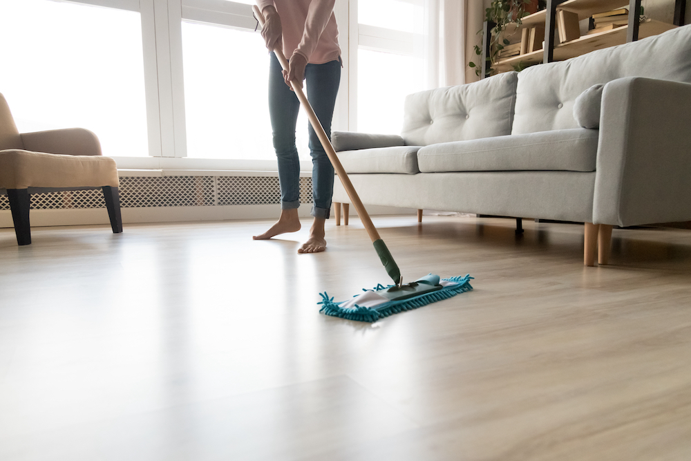 A woman mops the floors of her apartment