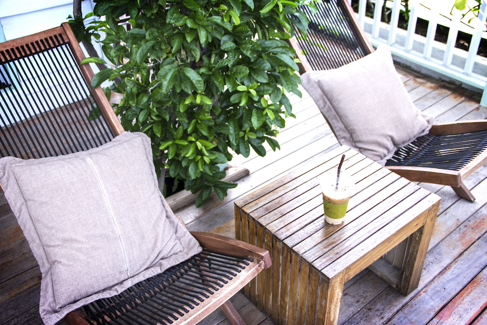 An outdoor apartment patio area with deck chairs and plants