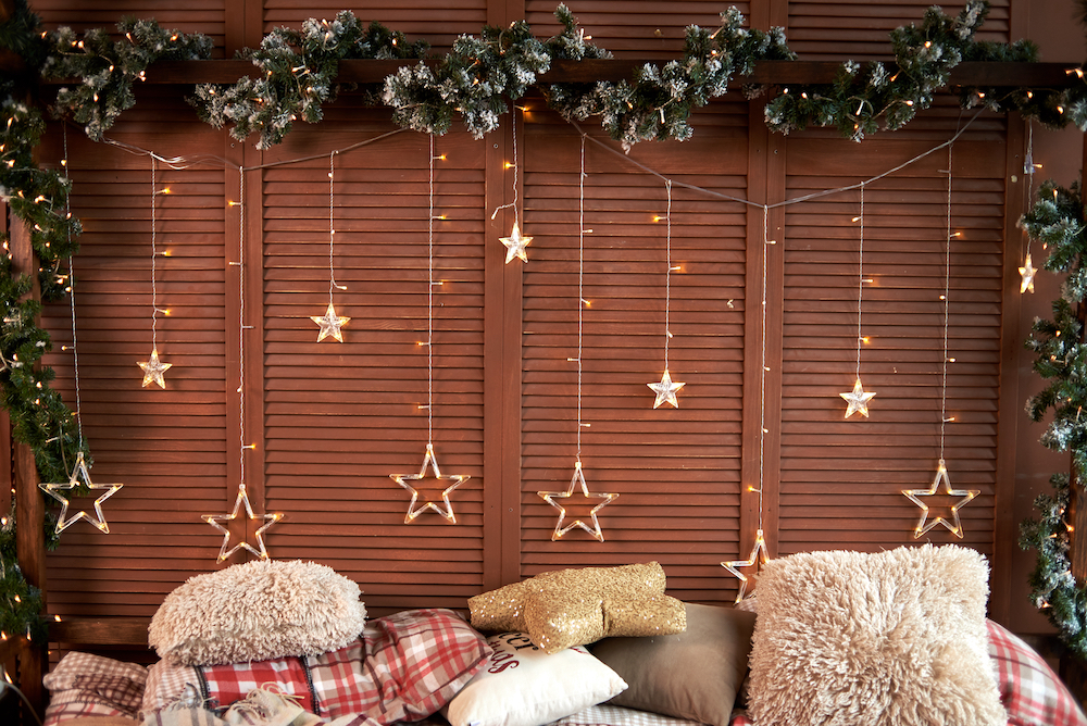 Holiday lights strung up behind a bed