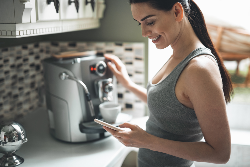 A woman at the luxury apartments in Westwood uses a smart coffee maker in her kitchen