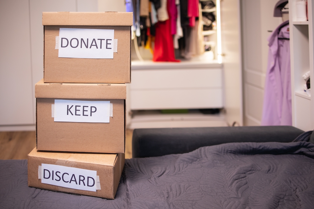 A stack of three boxes labeled donate, keep, and discard