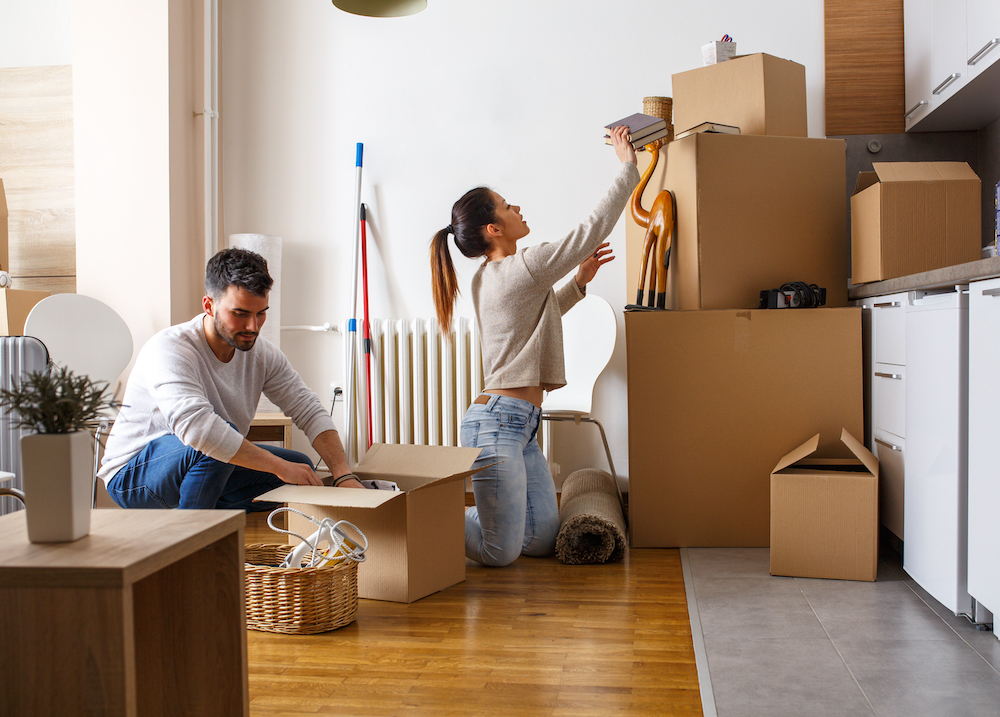 A young couple packing up boxes as they prepare to move to apartments in Westwood, KS