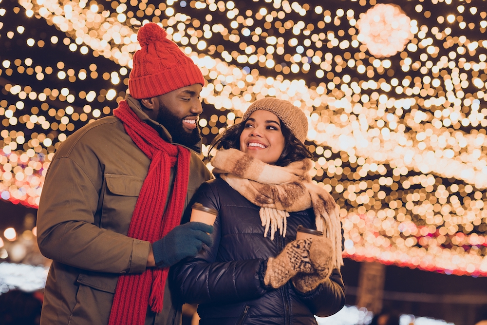 A young couple walking around and looking at the holiday light displays