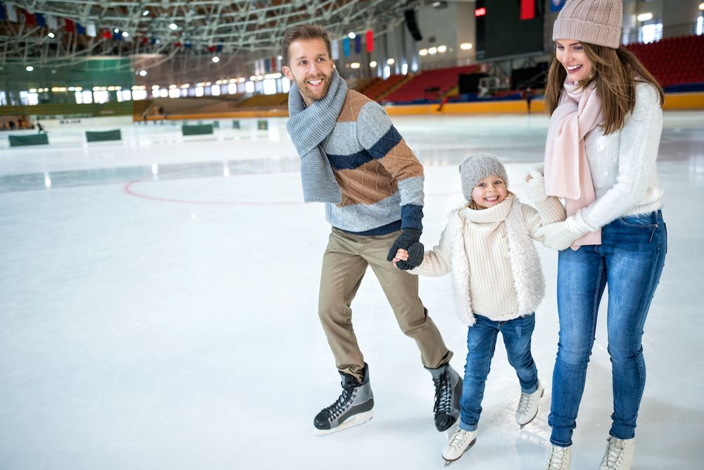 A young family ice skating at a rink near the best apartments in Kansas City