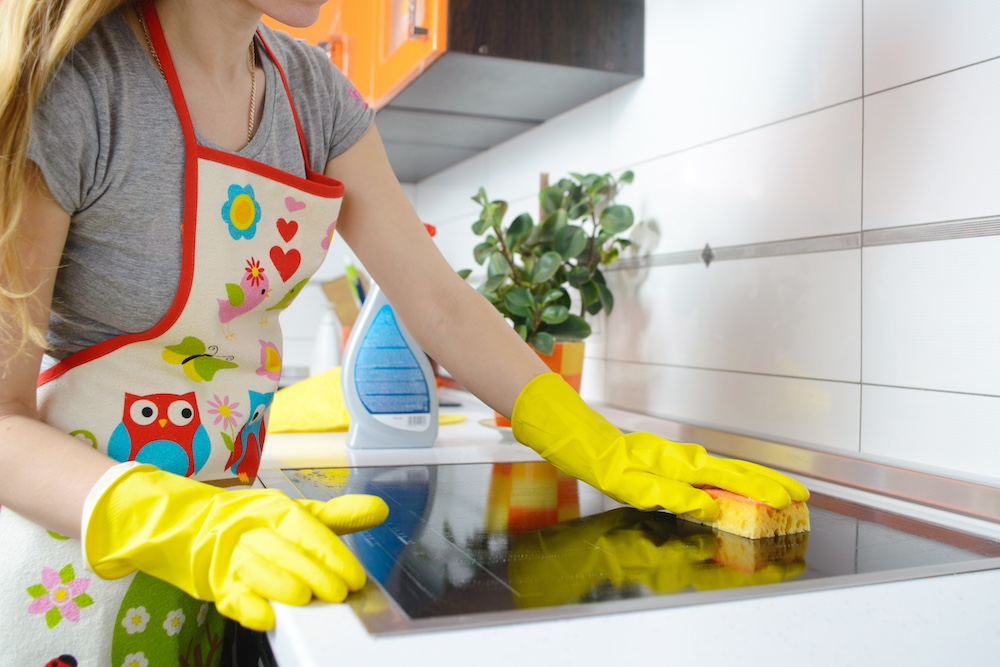 A woman scrubbing her stove