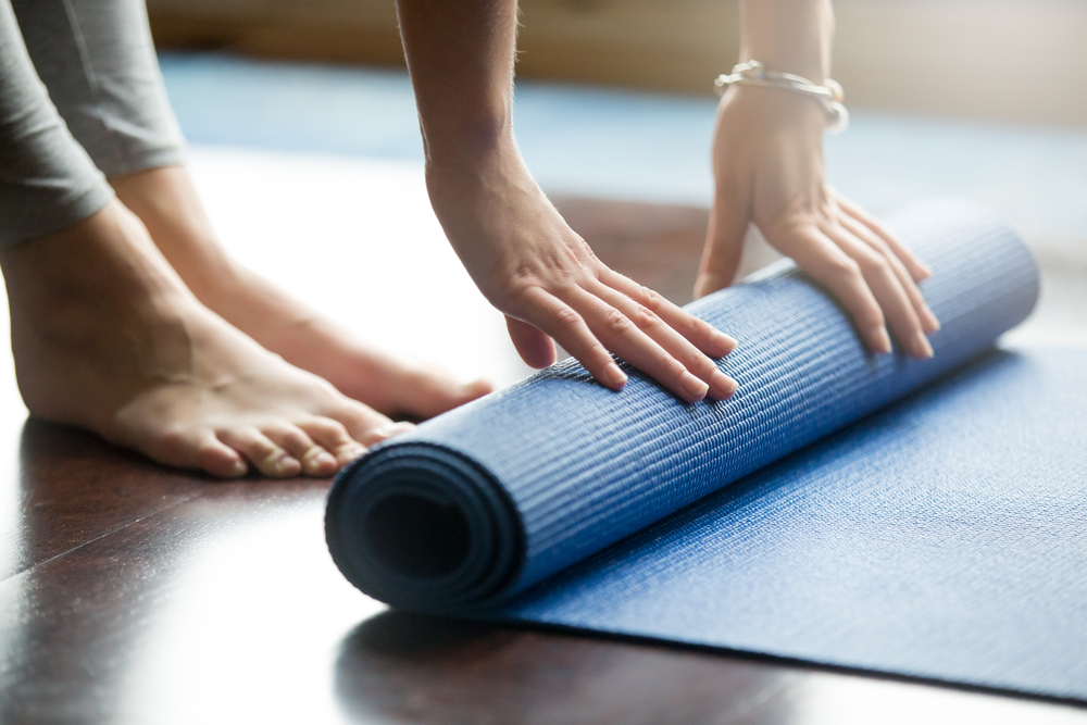 Person rolling yoga mat in apartments in Westwood, KS.