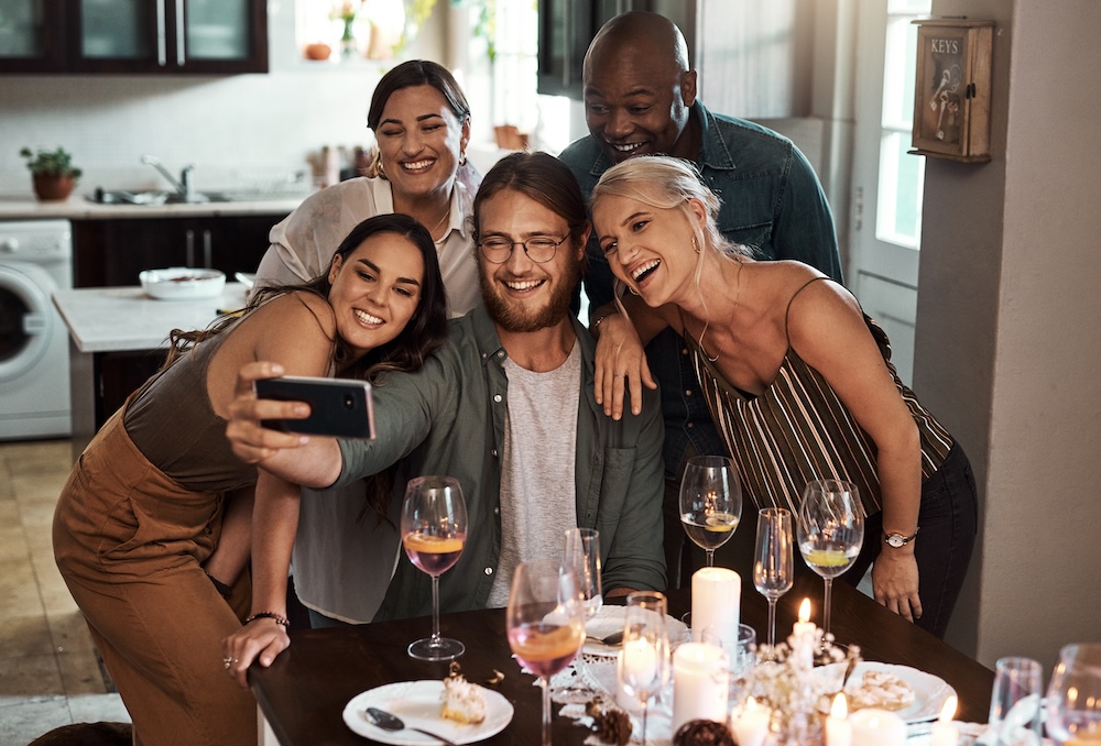 Group of friends having dinner together in their woodside village apartments