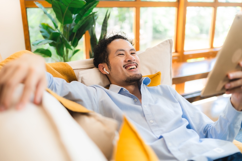 Young man relaxing on his couch in his luxury apartments for rent